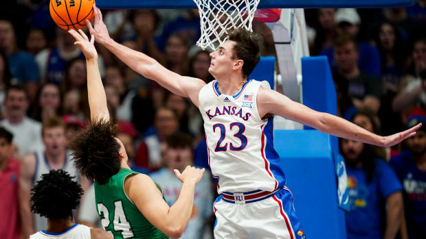 Nov 10, 2023; Lawrence, Kansas, USA; Kansas Jayhawks forward Parker Braun (23) blocks the shot of Manhattan Jaspers forward Xinyi Li (24) during the first half at Allen Fieldhouse. Mandatory Credit: Jay Biggerstaff-USA TODAY Sports  